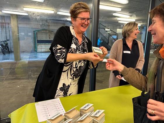 Lachende gezichten bij het uitdelen van bedrukte groeipapieren memoblokjes